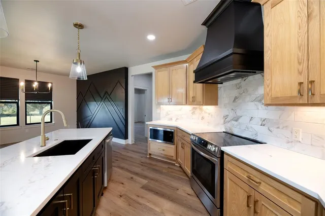 a kitchen with stainless steel appliances granite countertop a sink and a stove
