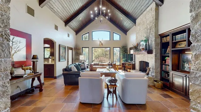 a living room with fireplace furniture and a large window