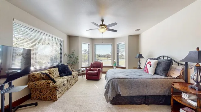 a living room with furniture ceiling fan and a large window