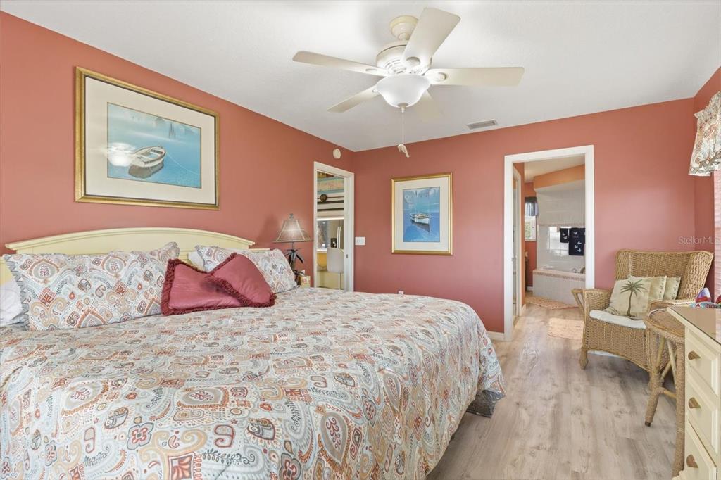 2882 North Comanche Point Crystal River, FL 34429 - Photo 14 of 39 a bedroom with a large bed and a chandelier