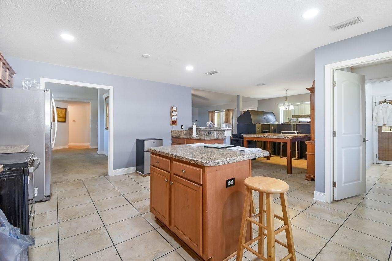 46 Riddle Drive Palm Coast, FL 32164 - Photo 6 of 20 a kitchen with granite countertop a stove a sink and a refrigerator