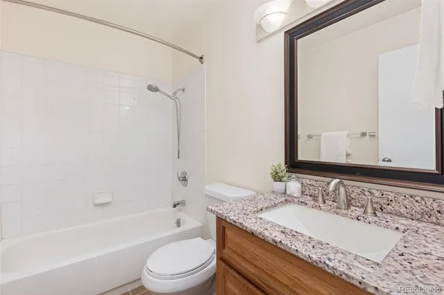 a bathroom with a granite countertop tub sink and mirror