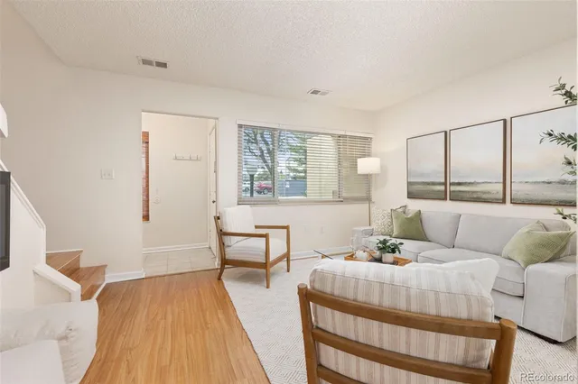 a living room with furniture and wooden floor