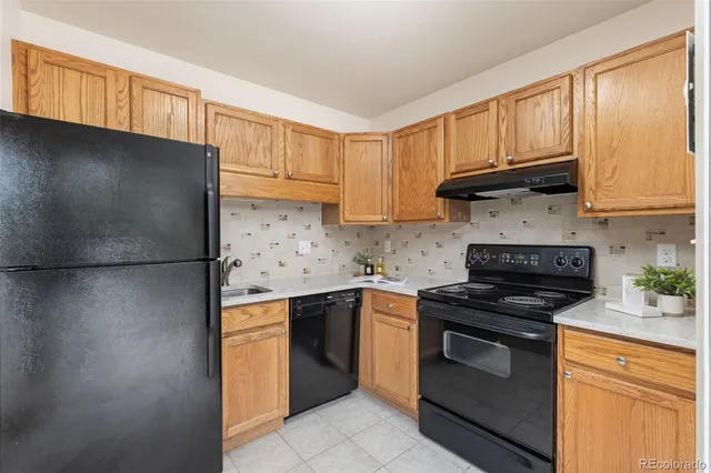 a kitchen with stainless steel appliances granite countertop a stove a refrigerator and a sink