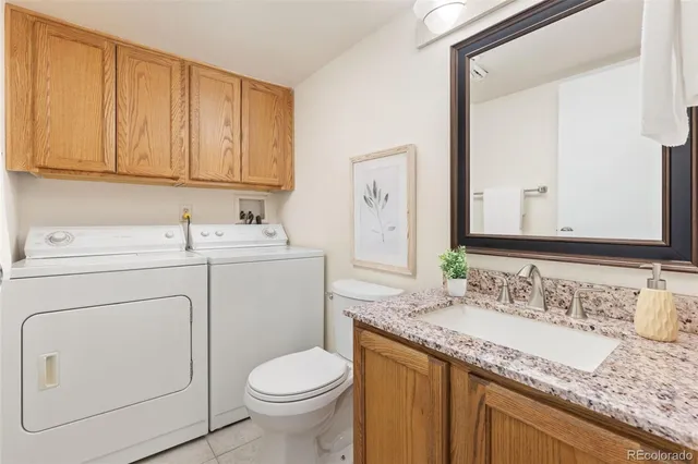 a bathroom with a granite countertop toilet sink and mirror