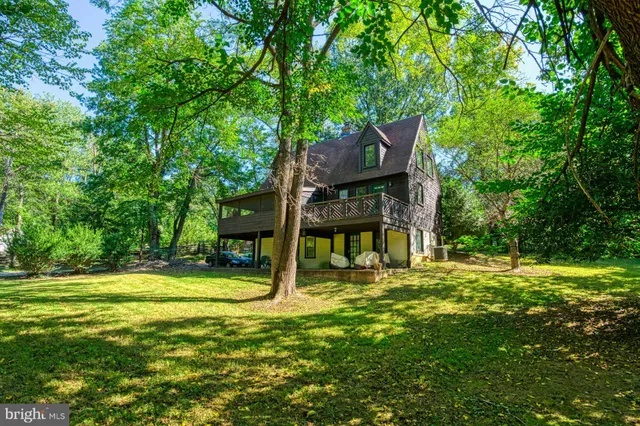 a view of a house with backyard and wooden fence