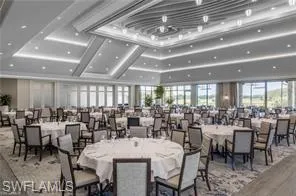 a room with lots of tables a large window and chairs