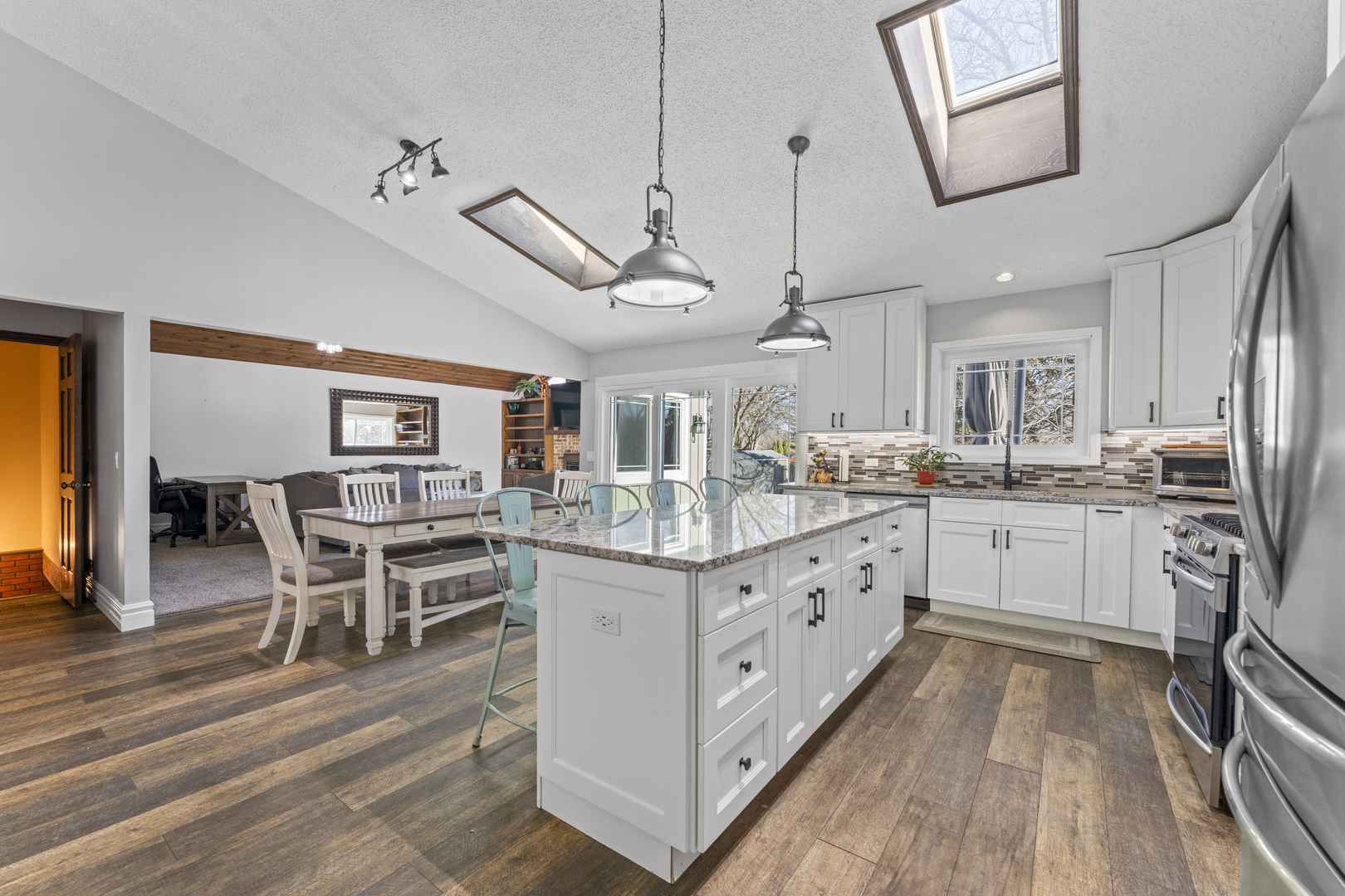 619 West End Road Roselle, IL 60172 - Photo 11 of 37 a kitchen with stainless steel appliances granite countertop a white cabinets and wooden floor