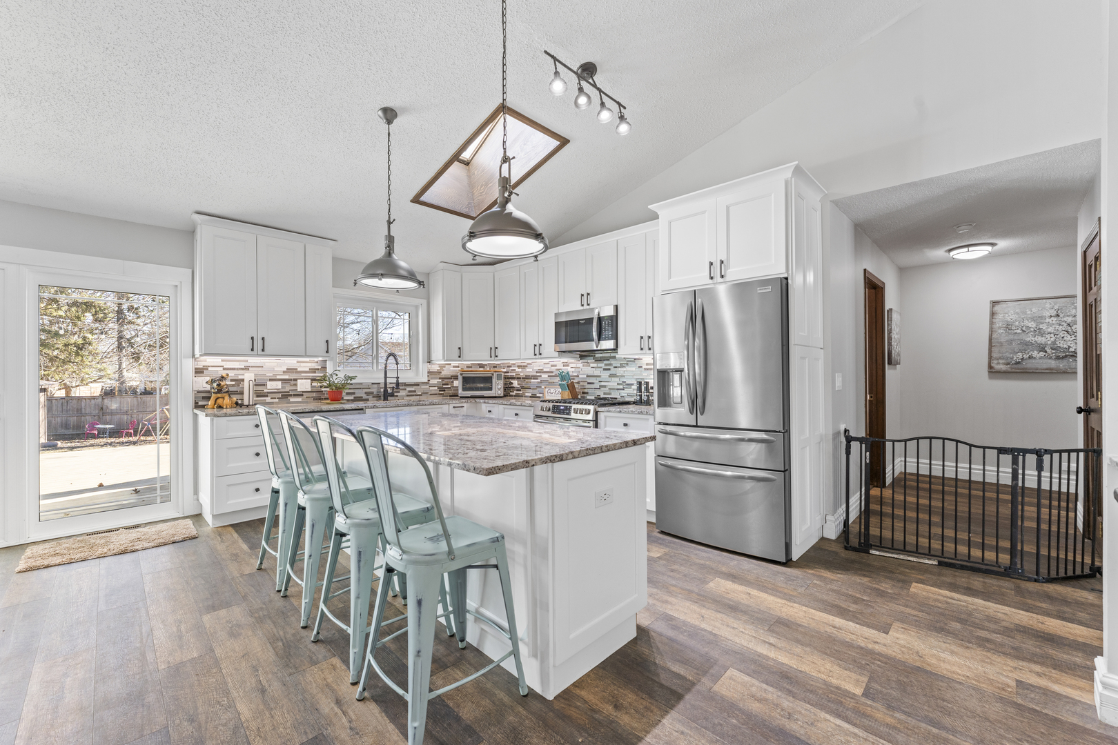 619 West End Road Roselle, IL 60172 - Photo 12 of 37 a kitchen with stainless steel appliances a refrigerator a stove a sink dishwasher a dining table and chairs with wooden floor