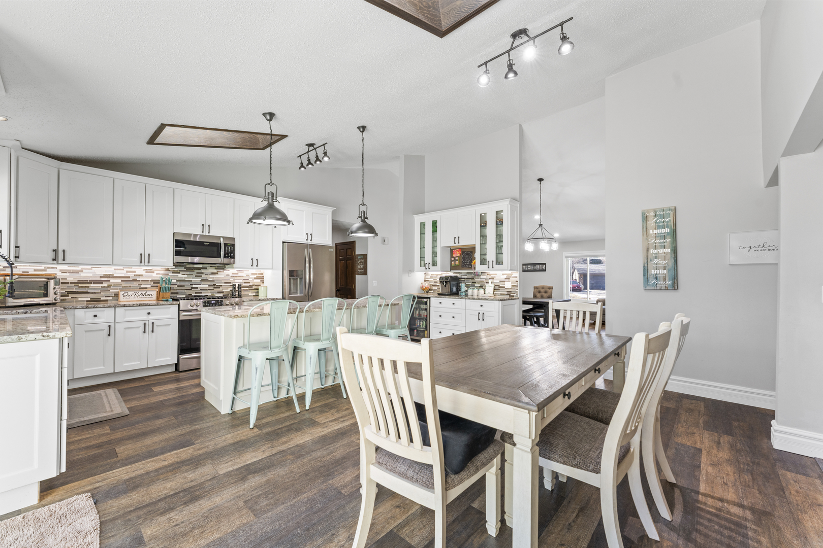 619 West End Road Roselle, IL 60172 - Photo 15 of 37 a kitchen with stainless steel appliances kitchen island granite countertop a dining table chairs and white cabinets