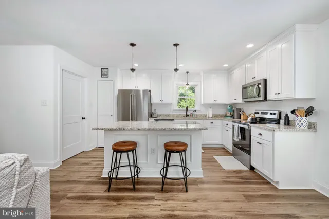 a kitchen with granite countertop cabinets stainless steel appliances and a counter space