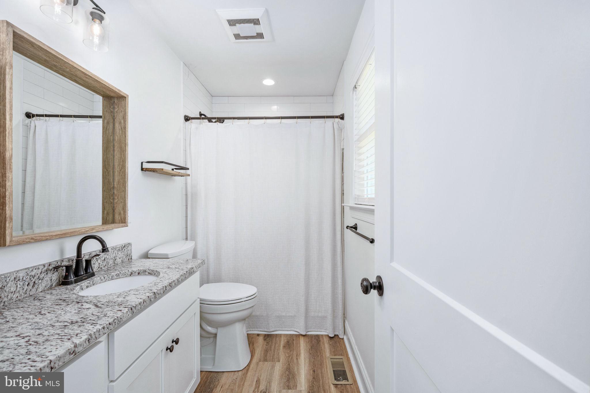 5712 Buckner Road Bumpass, VA 23024 - Photo 24 of 59 a bathroom with a granite countertop sink a toilet and shower