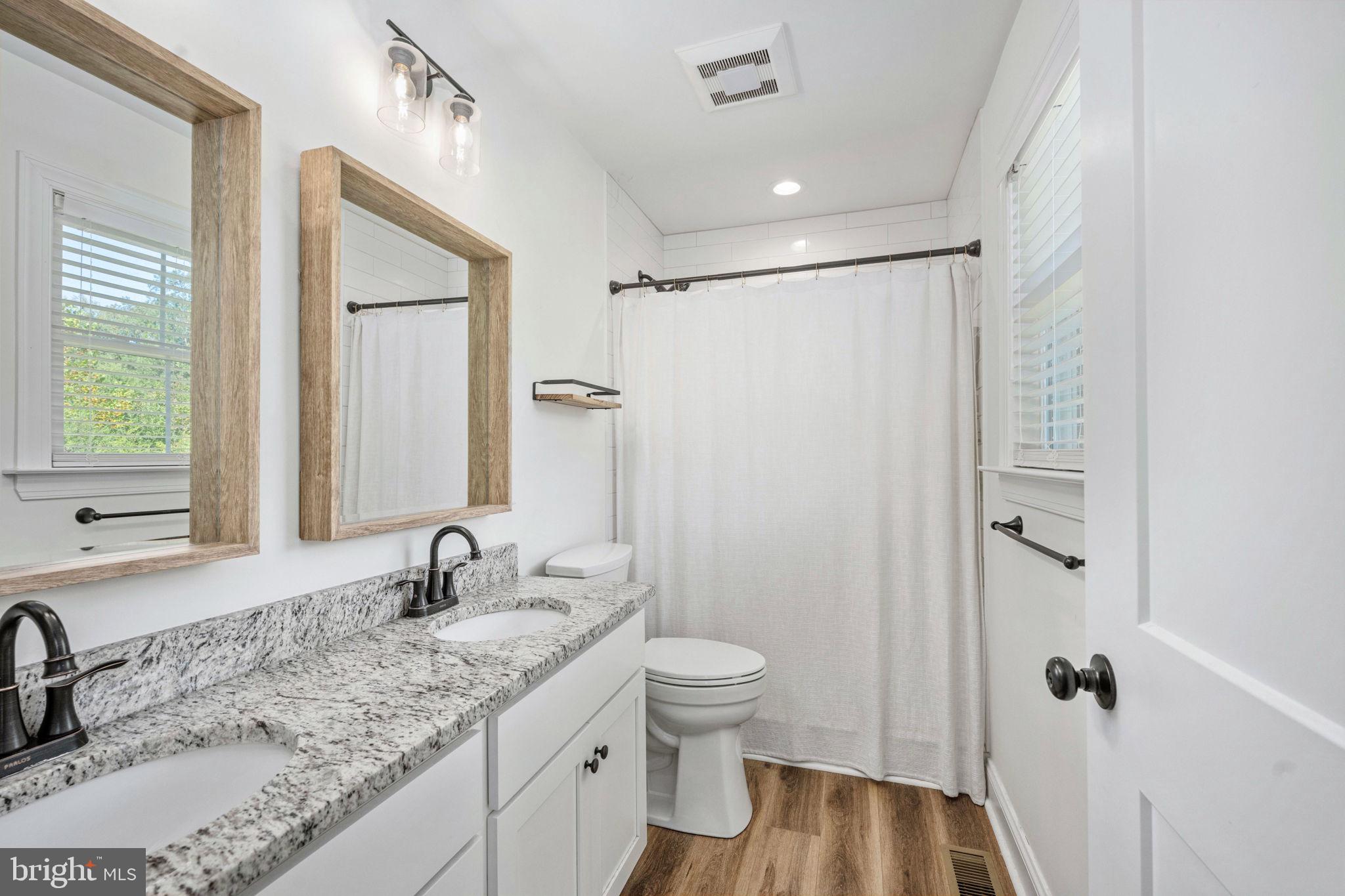 5712 Buckner Road Bumpass, VA 23024 - Photo 25 of 59 a bathroom with a granite countertop sink toilet and shower