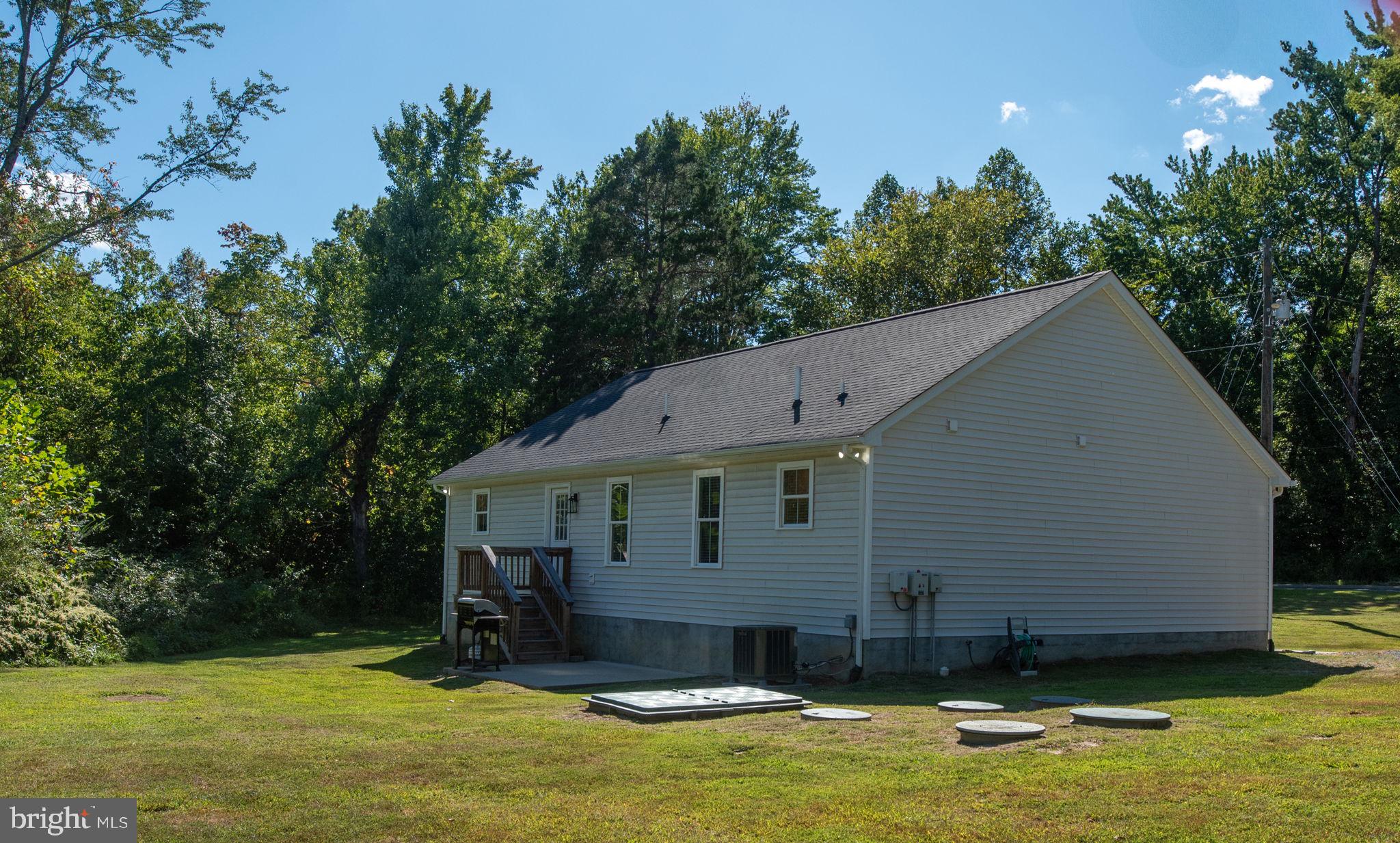 5712 Buckner Road Bumpass, VA 23024 - Photo 35 of 59 a house view with swimming pool and trees in the background