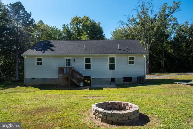 a view of a house with backyard and trees