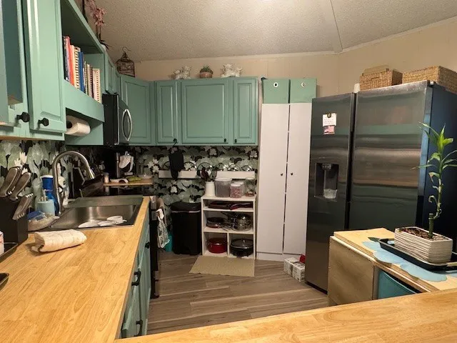 a view of a kitchen with refrigerator and chairs