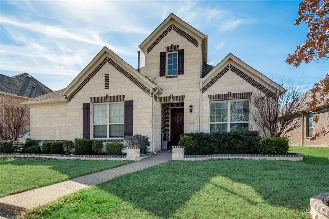 a front view of a house with a yard and green space