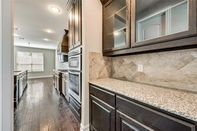 a view of a kitchen island wooden floor and stainless steel appliances