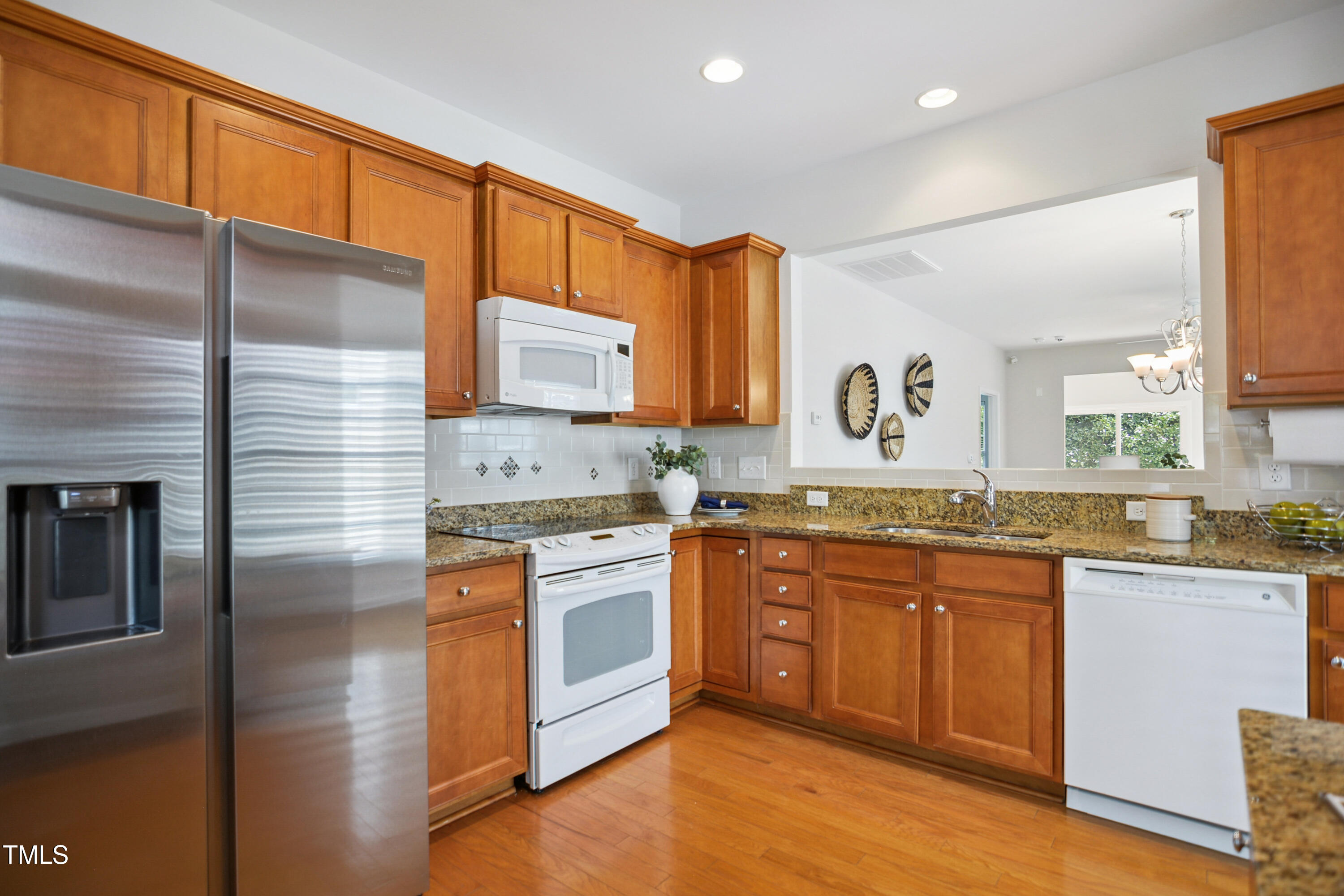 563 Tomkins Loop Cary, NC 27519 - Photo 11 of 26 a kitchen with stainless steel appliances granite countertop a sink and cabinets