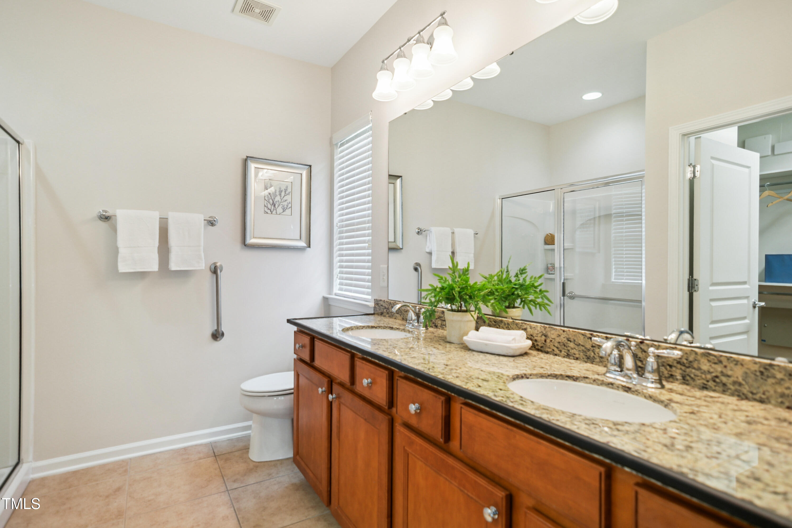 563 Tomkins Loop Cary, NC 27519 - Photo 15 of 26 a bathroom with a granite countertop double vanity sink a toilet and a mirror