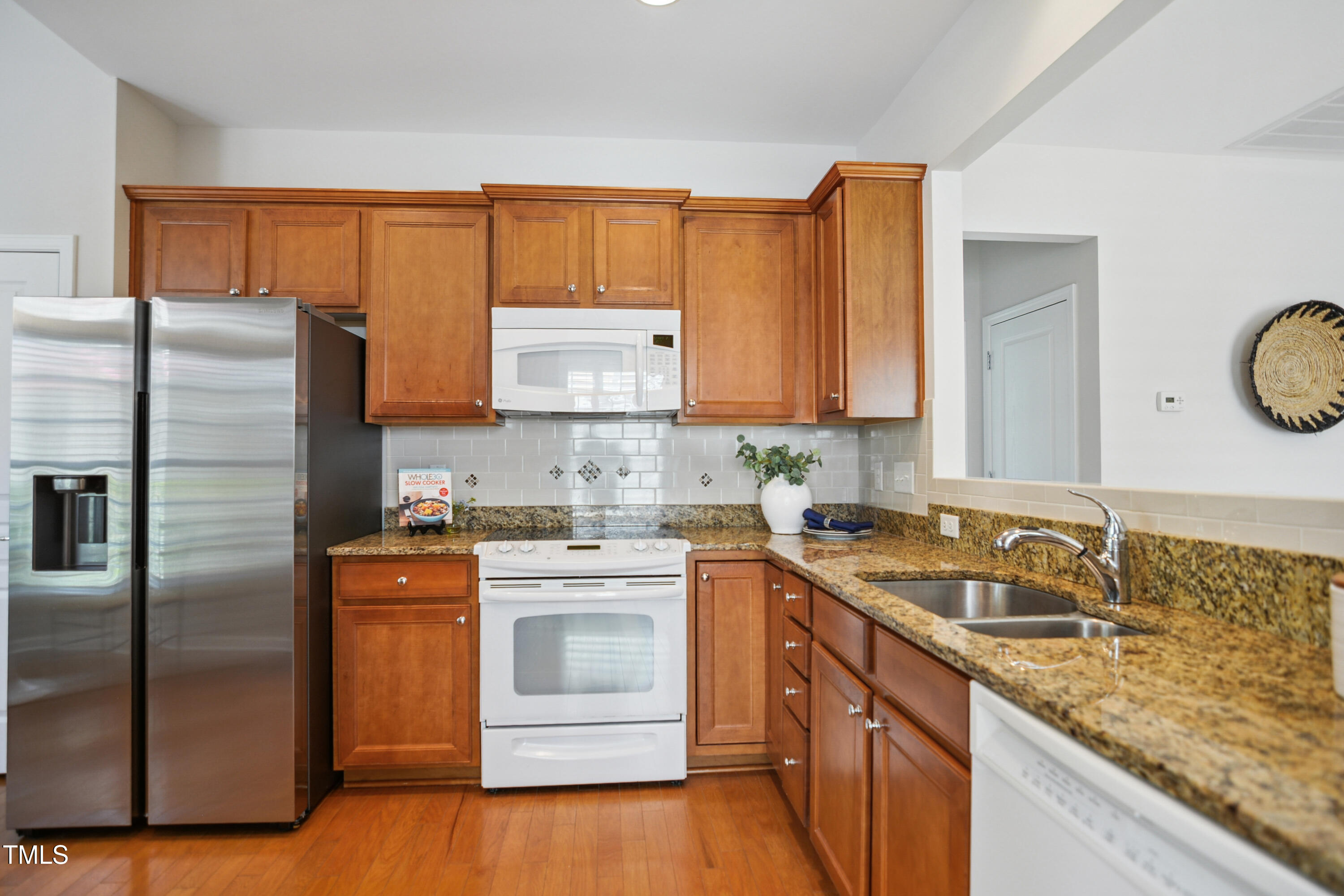 563 Tomkins Loop Cary, NC 27519 - Photo 9 of 26 a kitchen with stainless steel appliances granite countertop a sink stove and refrigerator