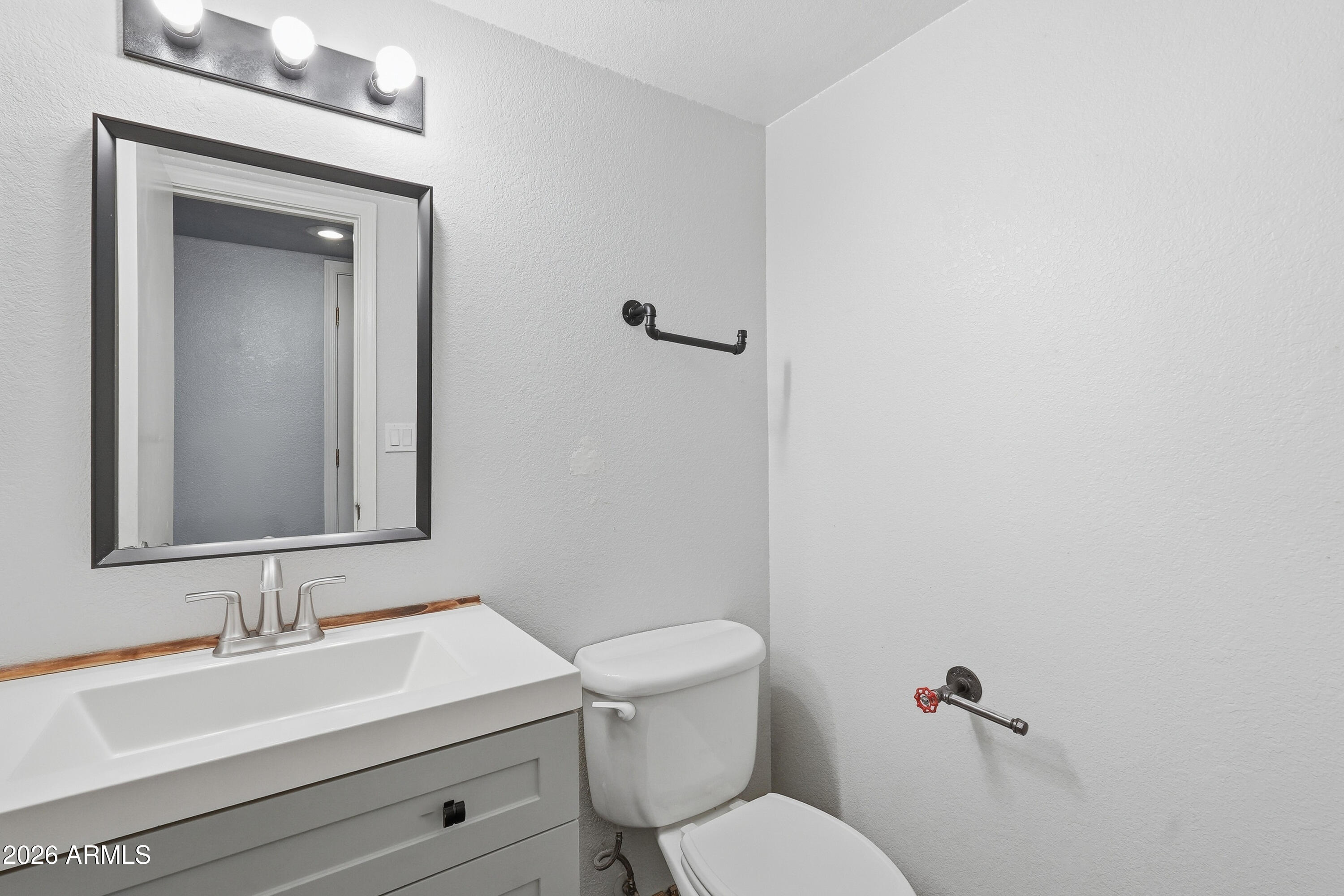 6262 East Brown Road, Unit 10 Mesa, AZ 85205 - Photo 25 of 33 a bathroom with a toilet sink vanity and mirror