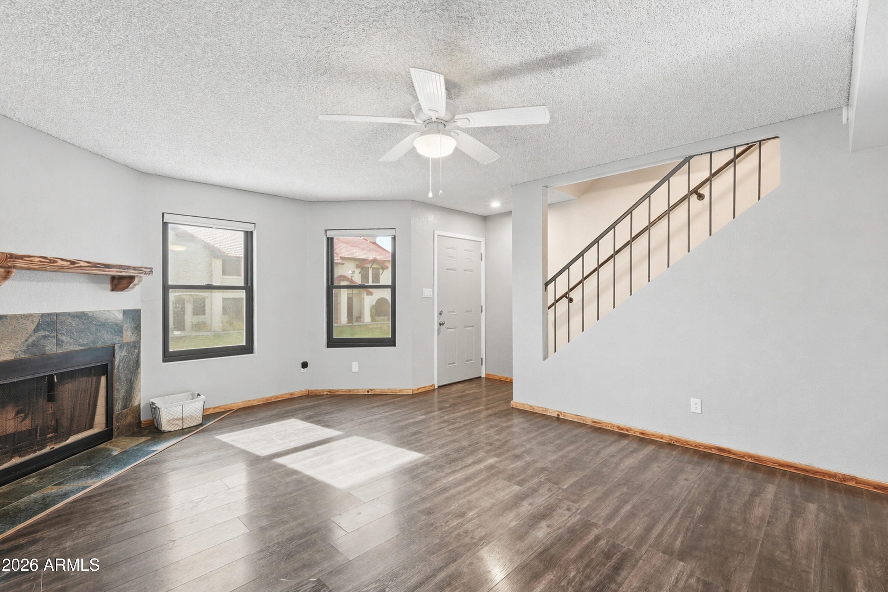 6262 East Brown Road, Unit 10 Mesa, AZ 85205 - Photo 10 of 33 a view of an empty room with wooden floor fireplace and a window
