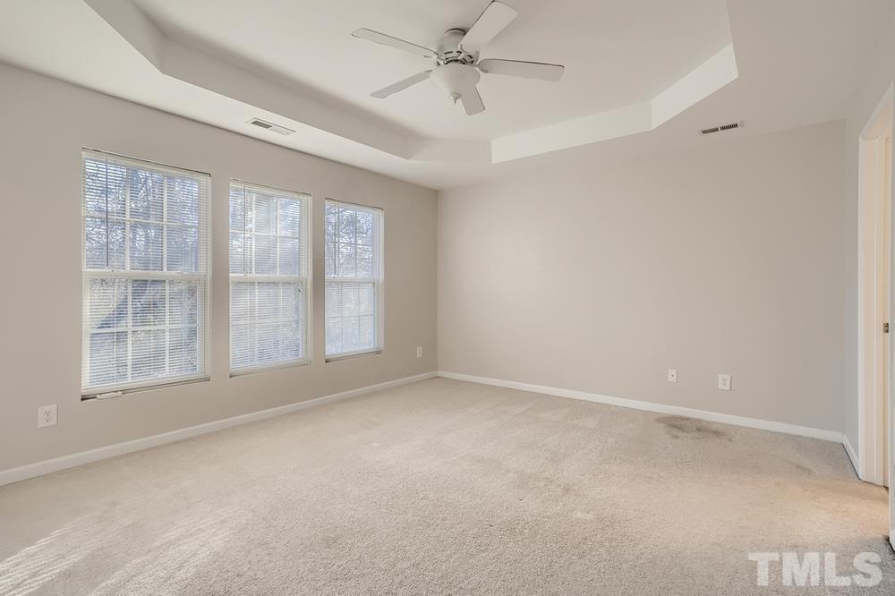 7012 Racine Way Raleigh, NC 27690 - Photo 15 of 28 an empty room with chandelier fan and windows