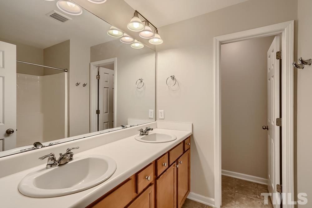 7012 Racine Way Raleigh, NC 27690 - Photo 17 of 28 a bathroom with a sink double vanity and a mirror