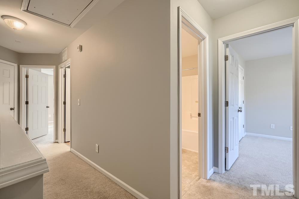 7012 Racine Way Raleigh, NC 27690 - Photo 24 of 28 a view of a hallway with wooden floor and a bathroom