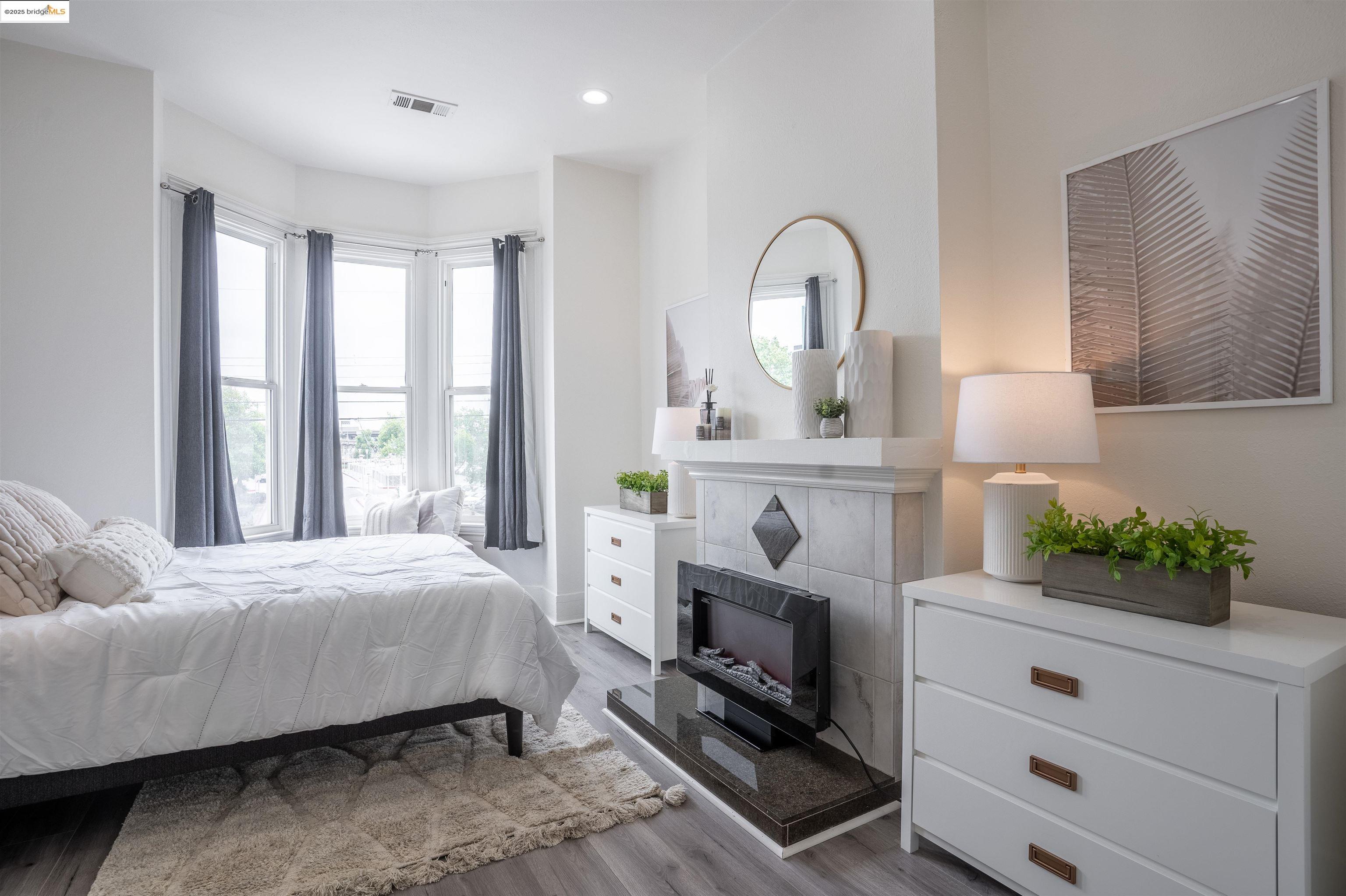 527 Chester Street Oakland, CA 94607 - Photo 40 of 59 Bedroom featuring light wood-style floors, a tile fireplace, multiple windows, and recessed lighting