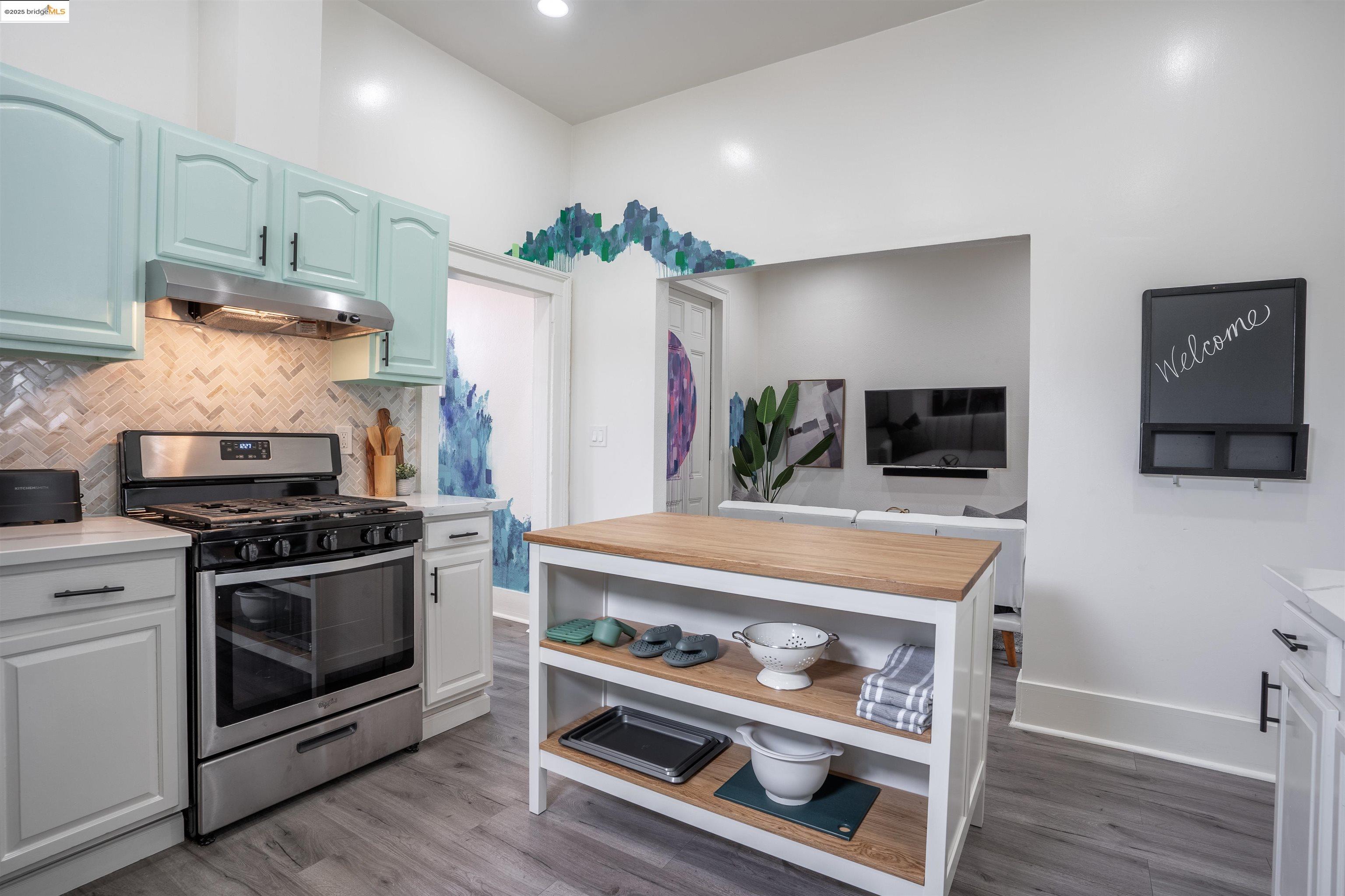527 Chester Street Oakland, CA 94607 - Photo 57 of 59 Kitchen featuring gas range, under cabinet range hood, light wood-style floors, backsplash, and wood counters