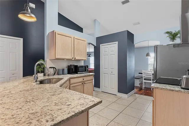 a kitchen with granite countertop a sink appliances and cabinets