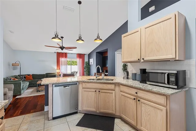 a kitchen with a sink dishwasher window and cabinets