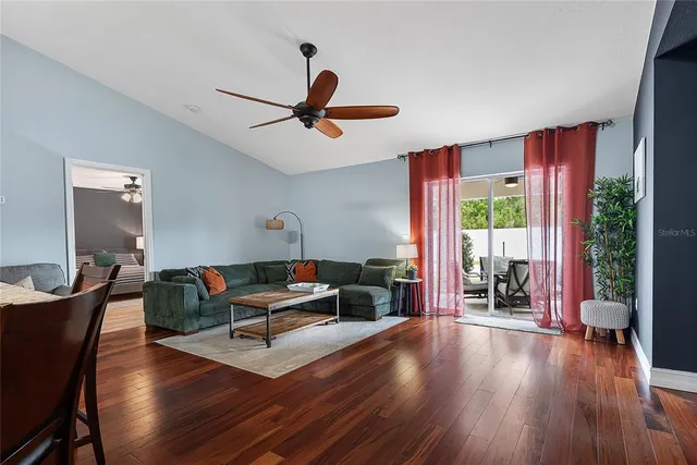 a living room with furniture and a wooden floor