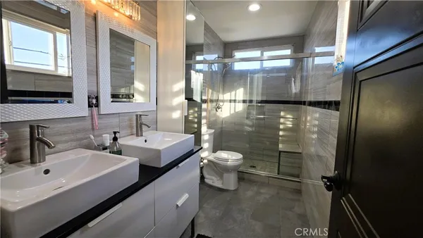 a bathroom with a double vanity sink toilet and a mirror