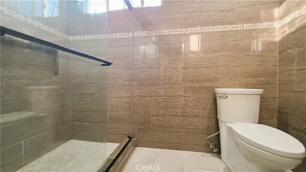 a bathroom with a toilet and a shower