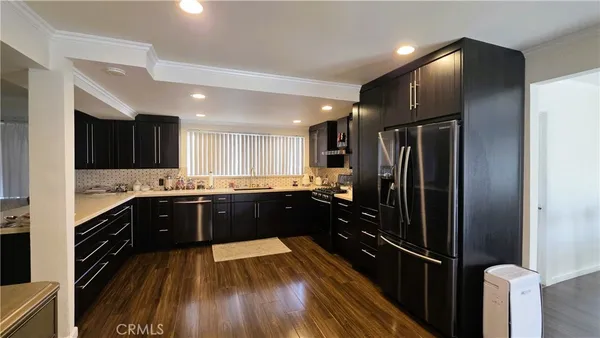 a large kitchen with a sink and refrigerator