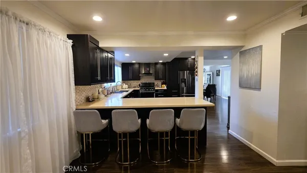 a kitchen with a dining table chairs cabinets and stainless steel appliances