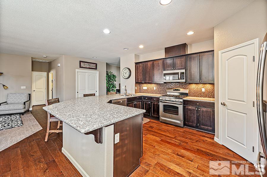2201 Dominic Drive Reno, NV 89521 - Photo 6 of 20 a kitchen with stainless steel appliances granite countertop a kitchen island a stove and a sink
