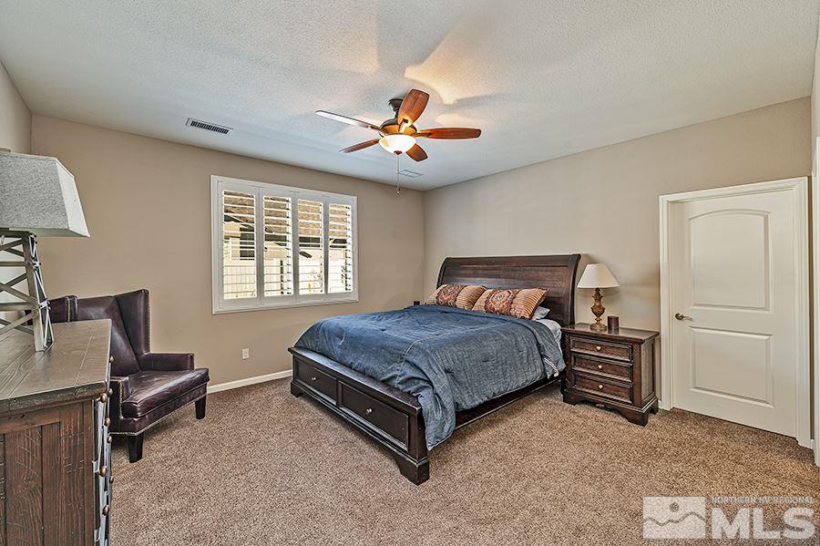 2201 Dominic Drive Reno, NV 89521 - Photo 10 of 20 a spacious bedroom with a bed and a chandelier