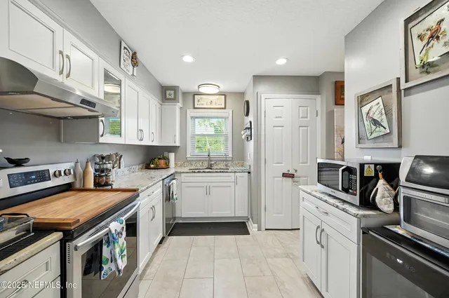 a kitchen with stainless steel appliances granite countertop a sink and cabinets