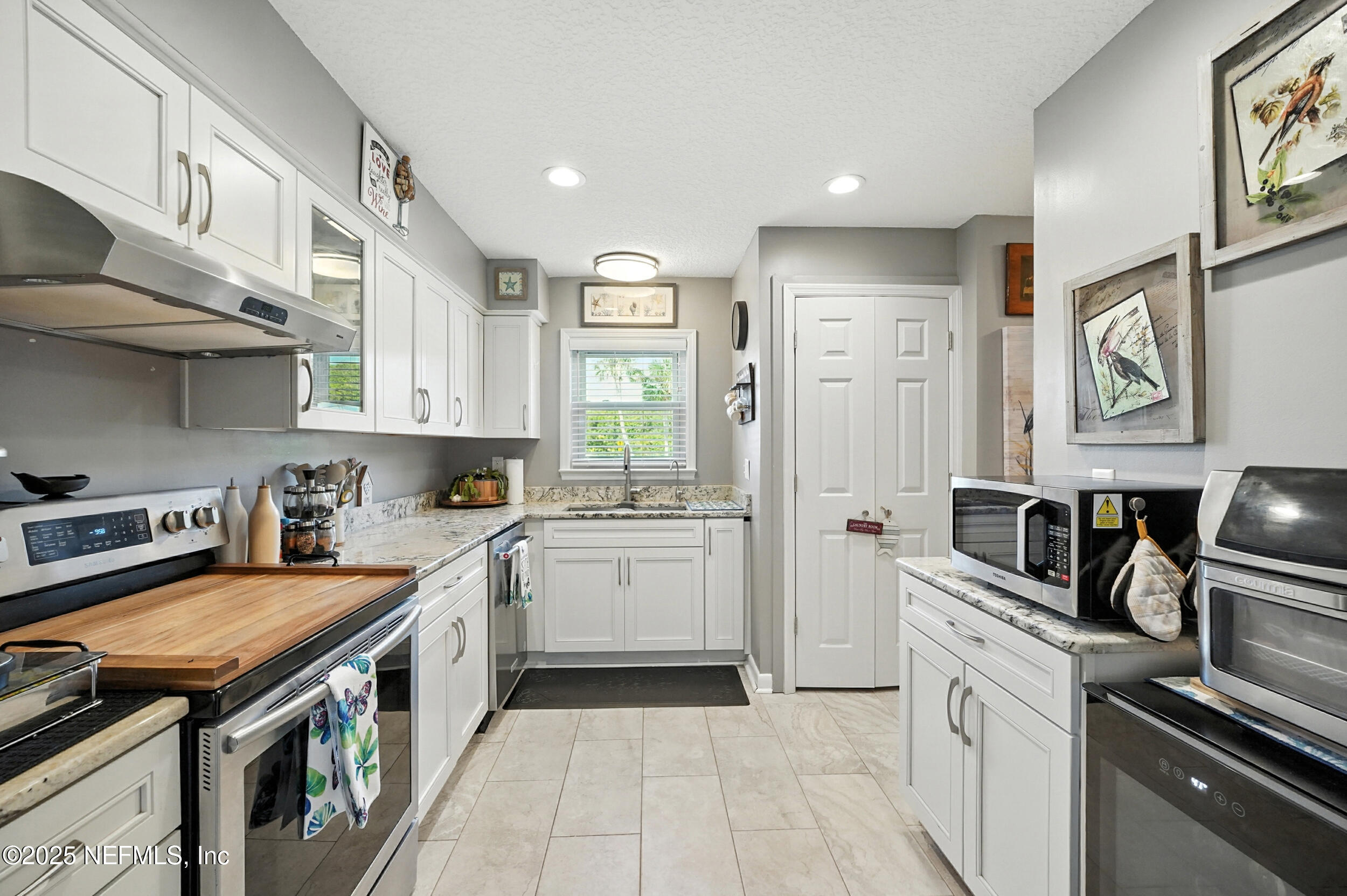 2233 Seminole Road, Unit 3 Atlantic Beach, FL 32233 - Photo 21 of 59 a kitchen with stainless steel appliances granite countertop a stove top oven a sink dishwasher and cabinets with wooden floor