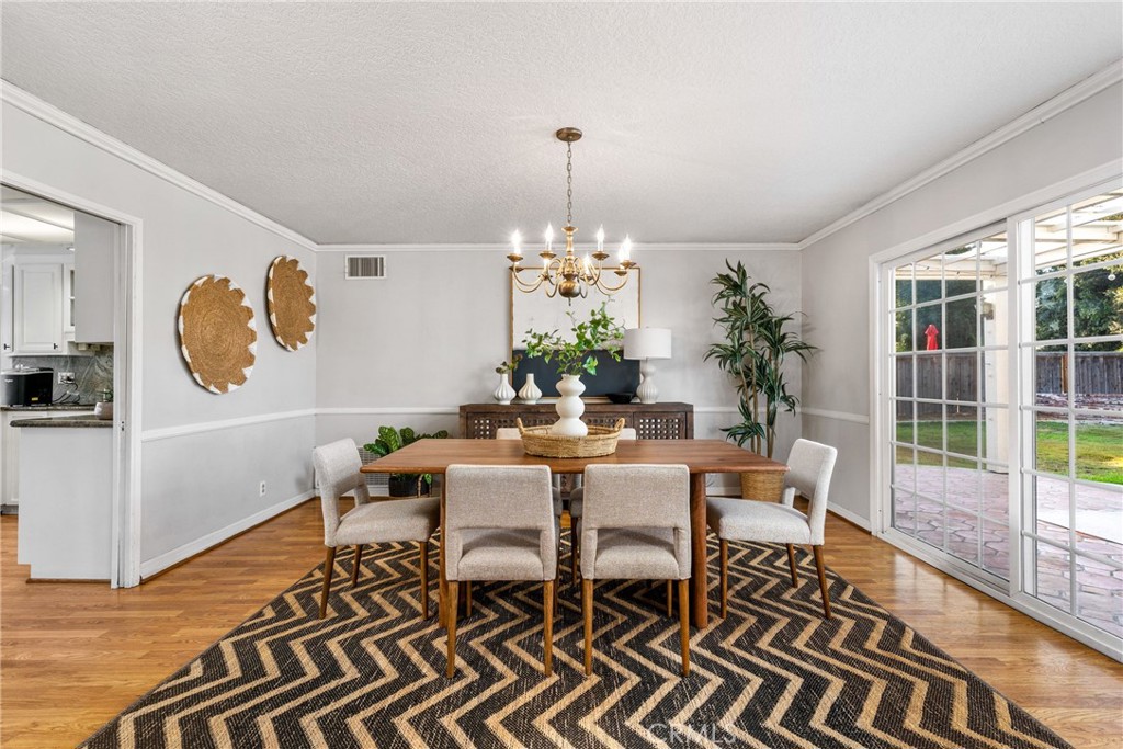 1856 Paros Circle Costa Mesa, CA 92626 - Photo 12 of 35 a dining room with furniture potted plants and wooden floor
