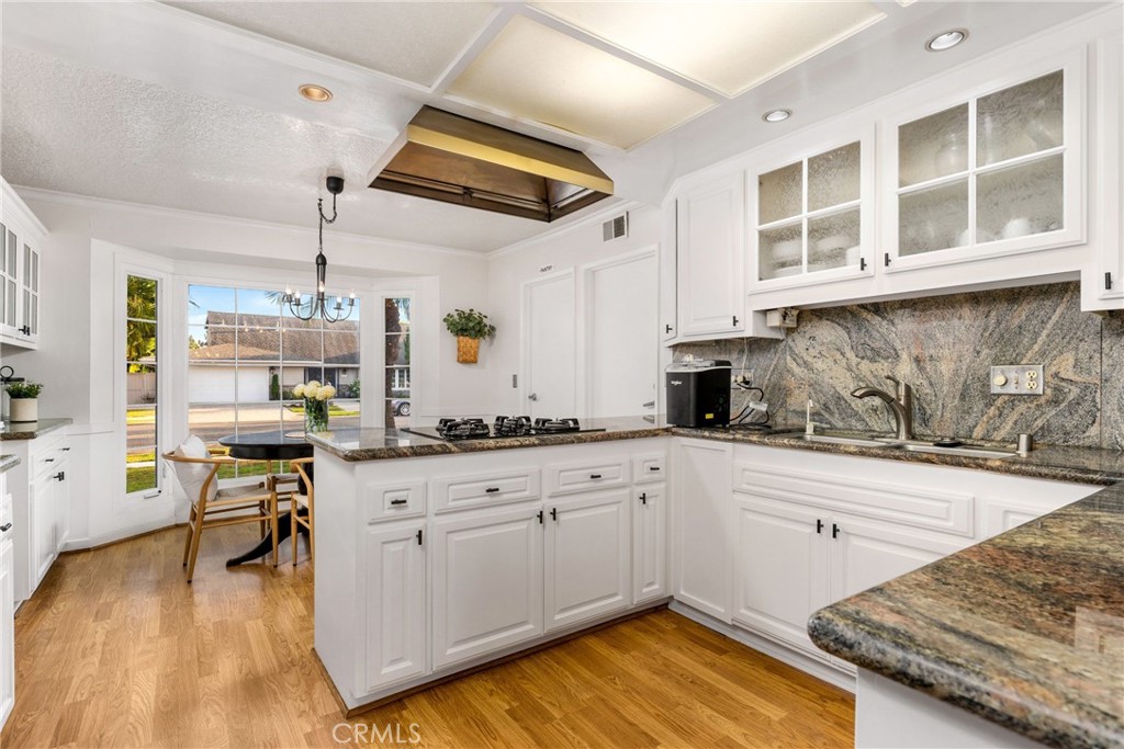 1856 Paros Circle Costa Mesa, CA 92626 - Photo 9 of 35 a kitchen with granite countertop a sink stove and wooden cabinets