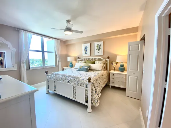 a bedroom with a large bed and a chandelier