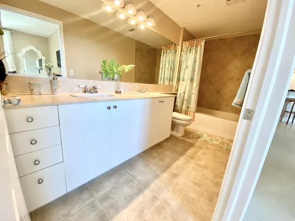 a bathroom with a double vanity sink mirror and shower