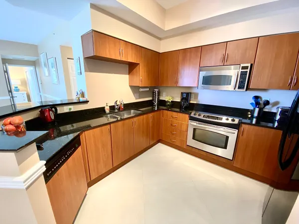 a kitchen with granite countertop a sink a stove and cabinets