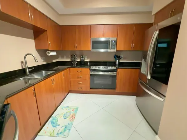 a kitchen with stainless steel appliances granite countertop a sink stove and refrigerator