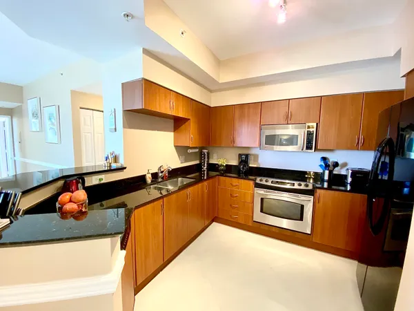 a kitchen with stainless steel appliances granite countertop a sink a stove and a refrigerator